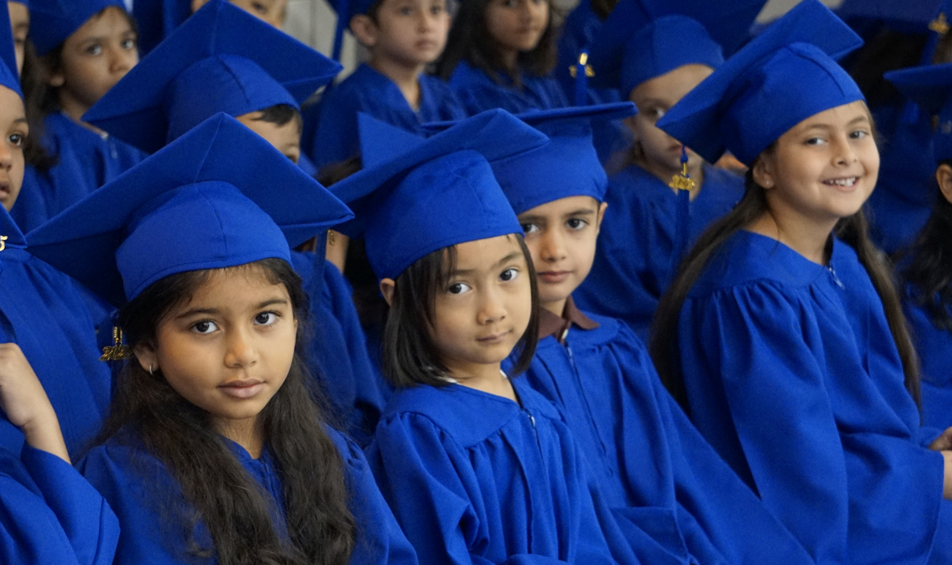 Elementary graduation ceremony with blue caps & gowns